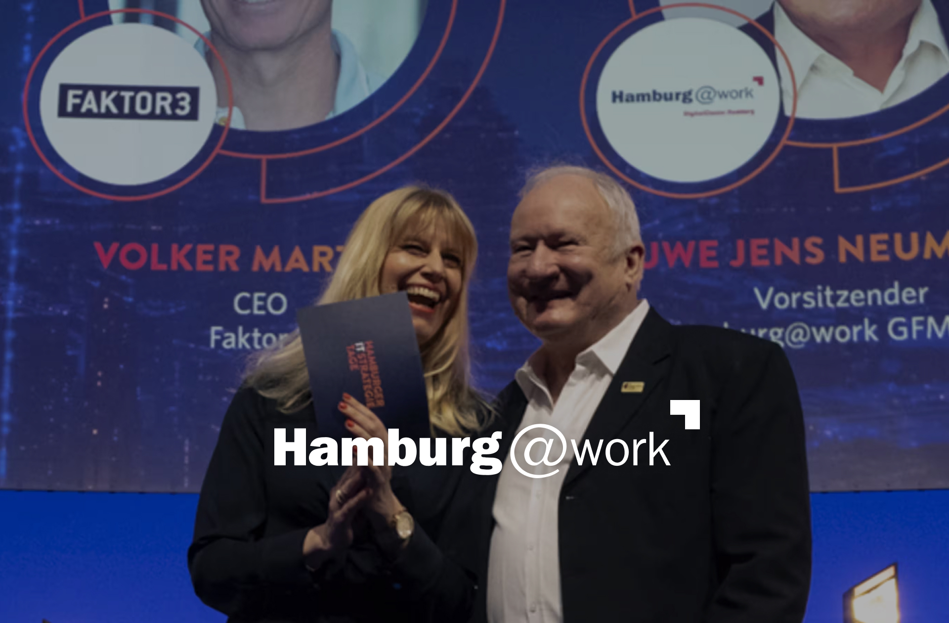 Zwei Personen stehen auf einer Bühne und Lachen