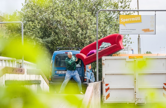 Mann entsorgt Sofa bei der Bremer Stadtreinigung